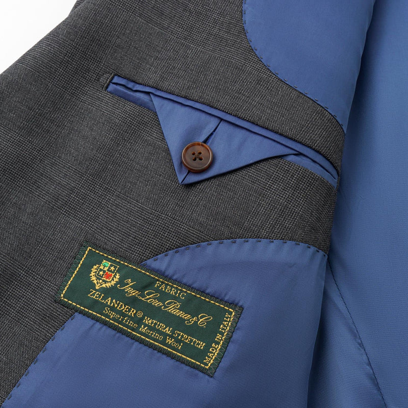 Close-up of a gray and blue jacket with a brand label on a white background
