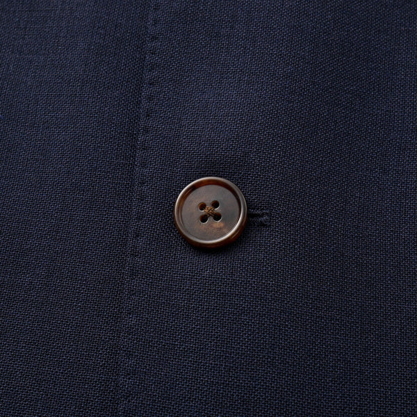 Close-up of a brown button on a dark blue fabric background