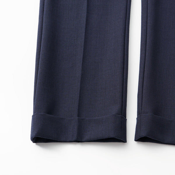 Navy blue pants with cuffed hems on a white background